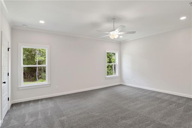 Empty room featuring a ceiling fan, baseboards, a wealth of natural light, and dark carpet | Image 25