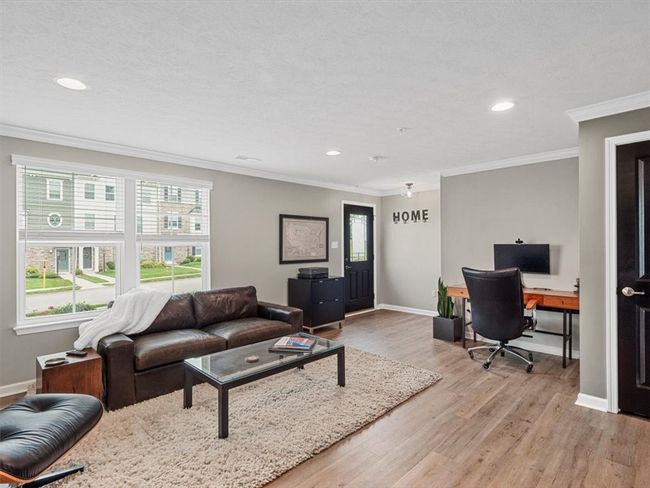 The space boasts wide-plank hardwood flooring, recessed lighting, and soft gray walls that create a serene, modern ambiance. | Image 4