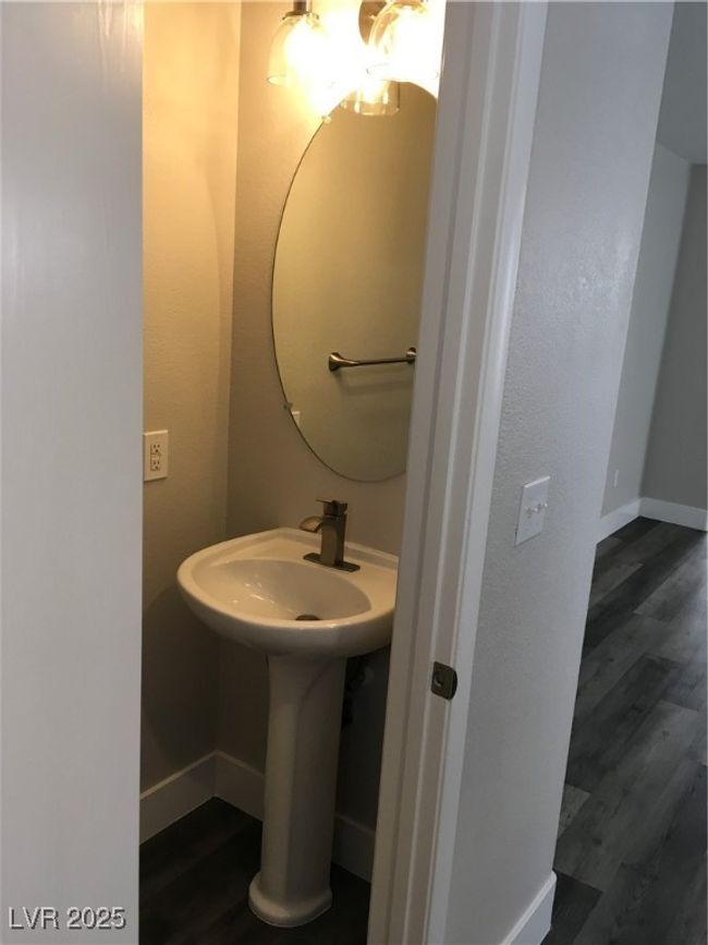 Bathroom featuring a sink, wood finished floors, and baseboards | Image 13