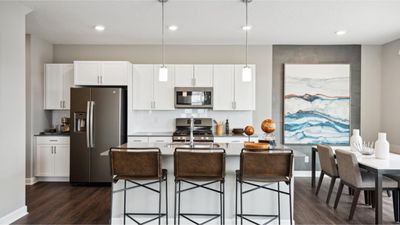 (Photo of decorated model, actual home's finishes will vary) A spacious center island, stainless steel appliances and plenty of cabinet storage come together to create a stylish and efficient kitchen. | Image 1