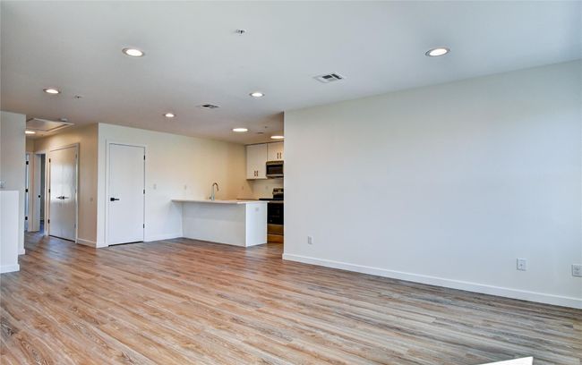 Unfurnished living room with recessed lighting, visible vents, baseboards, and light wood finished floors | Image 31