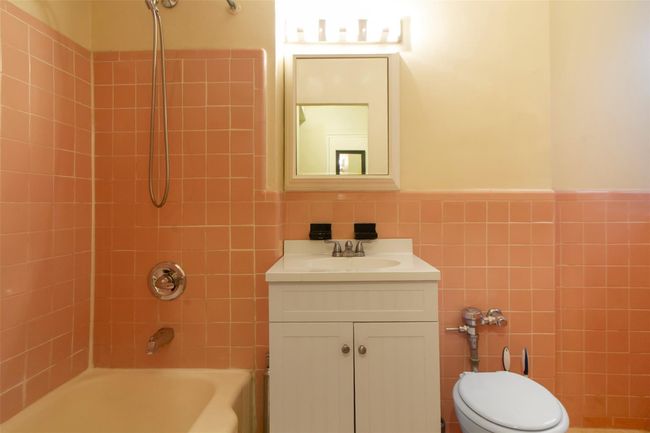 Full bath featuring tile walls, a wainscoted wall, shower / bath combination, and vanity | Image 12