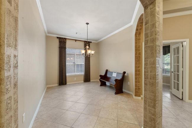 Next to the study is the formal dining room, enhanced with crown molding and an elegant uplight chandelier. Ideal for hosting gatherings and special occasions in an cozy setting. | Image 11