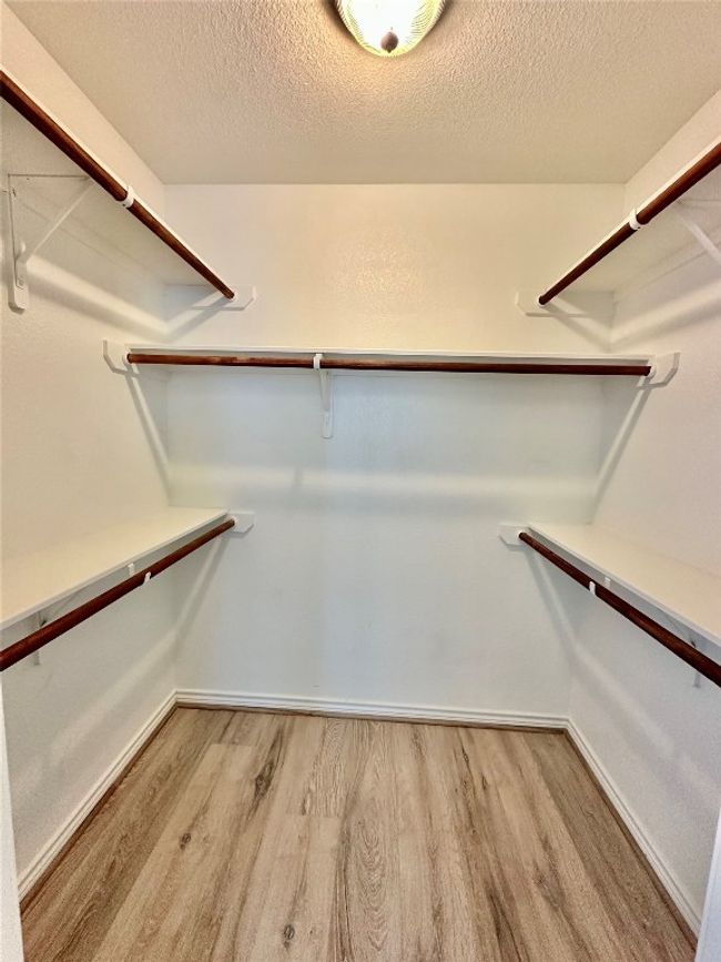 Walk in closet featuring light wood-style floors | Image 14
