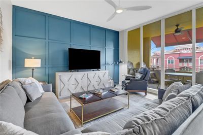 Living room with ceiling fan and light wood-type flooring | Image 1