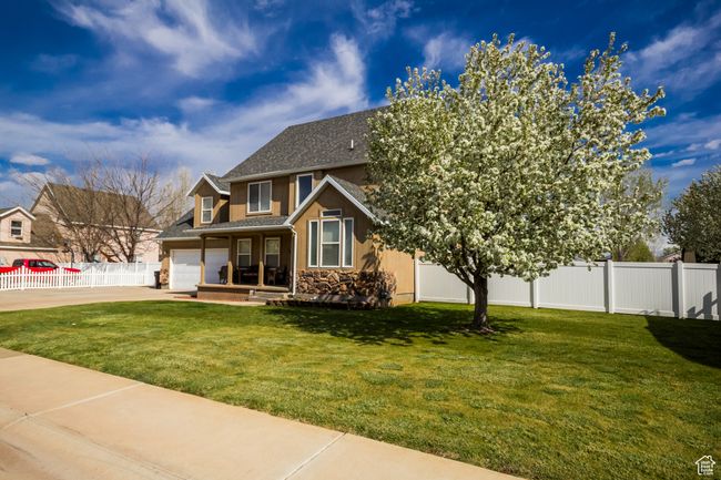 View of front of house featuring fence, stone siding, roof with shingles, a front lawn, and concrete driveway | Image 31
