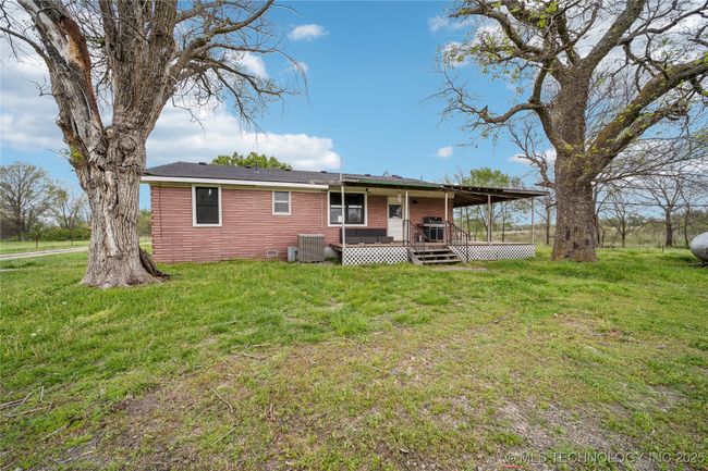 Rear view of property with a yard, central AC unit, and a wooden deck | Image 26