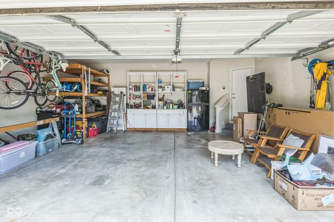 garage featuring freestanding refrigerator and a garage door opener | Image 30