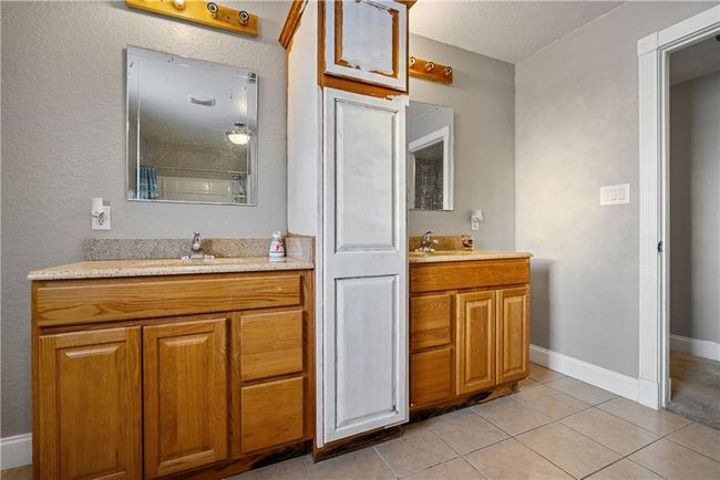Bathroom with tile patterned flooring, vanity, and a textured ceiling | Image 36