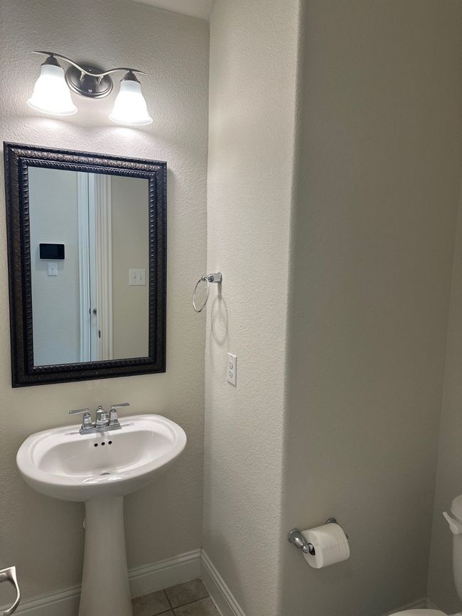 Bathroom with toilet, tile patterned flooring, and baseboards | Image 8
