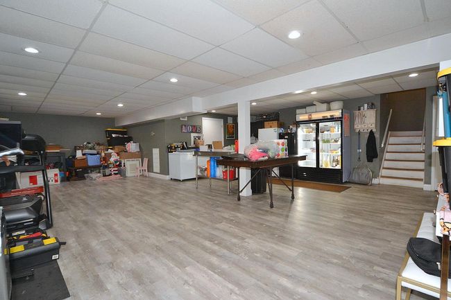 Finished below grade area featuring a paneled ceiling, recessed lighting, stairway, and wood finished floors | Image 21