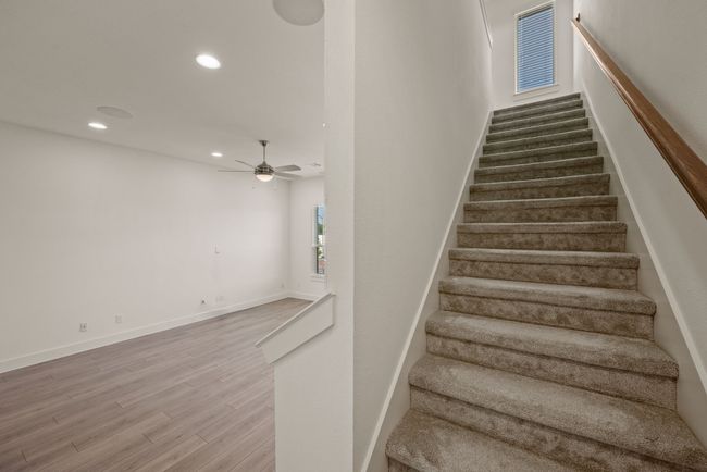 Staircase featuring baseboards, wood finished floors, recessed lighting, and ceiling fan | Image 22