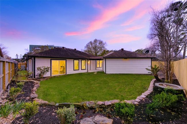 The backyard provides ample space for outdoor activities, with a large, open area perfect for creating your ideal outdoor retreat. The freshly landscaped yard complements the updated interior of the home, providing a seamless transition between indoor and outdoor living. | Image 28
