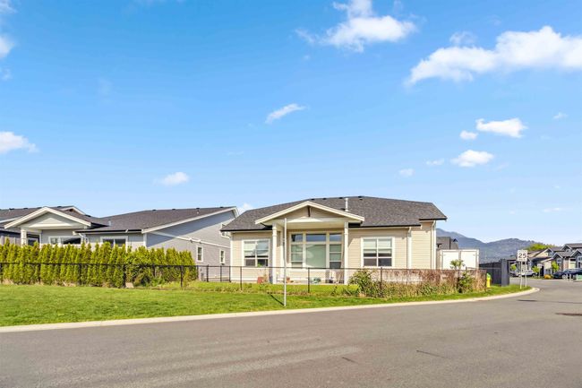 View of front of house featuring a fenced front yard, a front lawn, a shingled roof, a mountain view, and a residential view | Image 7