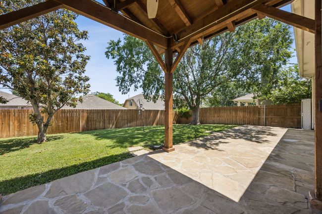 Fenced backyard featuring a full length flagstone patio area | Image 26