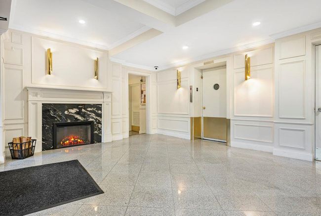 Unfurnished living room with a decorative wall, granite finish floor, a fireplace, ornamental molding, and recessed lighting | Image 12