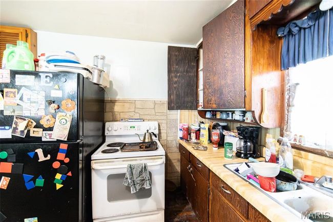 Kitchen featuring white range with electric stovetop, freestanding refrigerator, and light countertops | Image 9