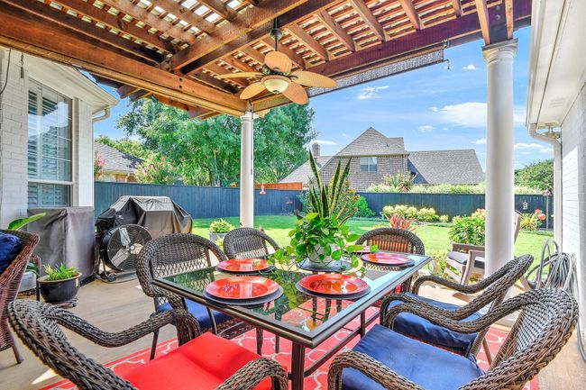 Fenced backyard featuring outdoor dining area, a ceiling fan, grilling area, and a patio | Image 33