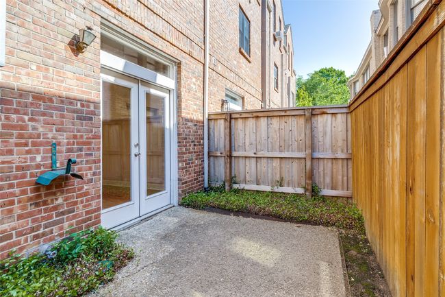 Patio for relaxing also has access to the back driveway where the garage is located and 1 uncovered parking space behind the garage. | Image 25