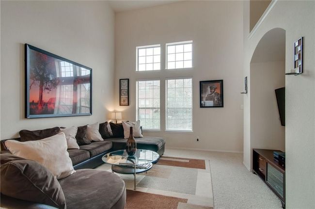 Carpeted living room with a high ceiling | Image 17