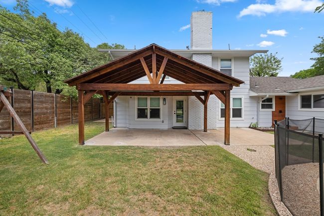 Rear view of house featuring a lawn, a fenced backyard, a chimney, and a patio | Image 34