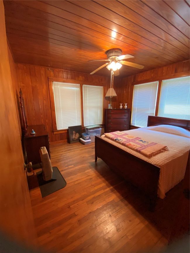 Bedroom with wood ceiling, wooden walls, and hardwood / wood-style floors | Image 19