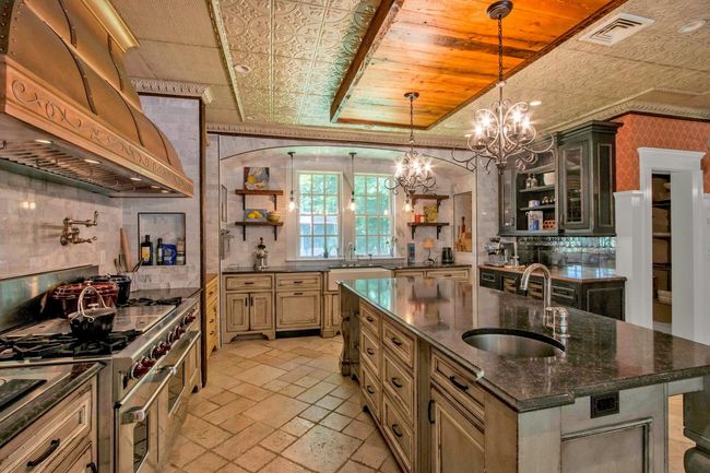 Kitchen with open shelves, a sink, premium range hood, double oven range, and a chandelier | Image 10
