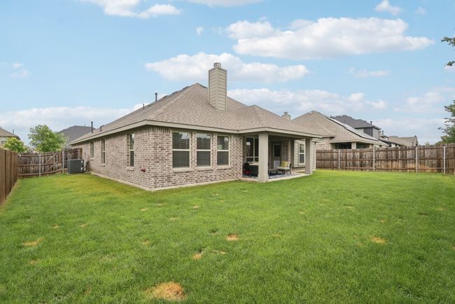 Rear view of property with brick siding, central AC, a chimney, a patio, and a shingled roof | Image 37