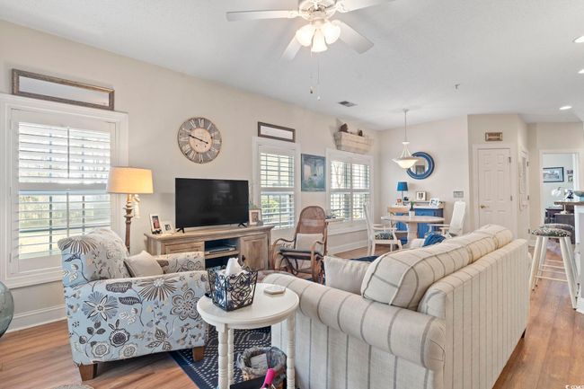 Living room with wood finished floors, a ceiling fan, and plenty of natural light | Image 16