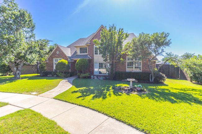 Traditional home featuring brick siding and roof with shingles | Image 29