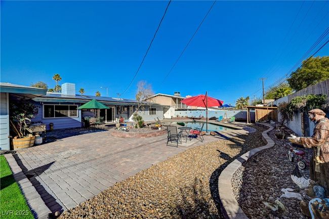Back of house with a patio area, a fenced backyard, and solar panels | Image 16