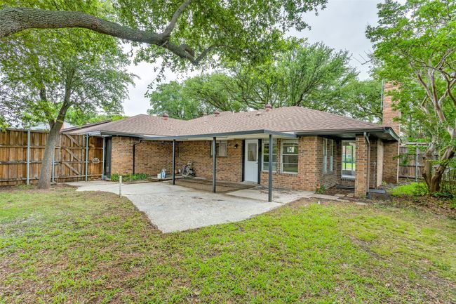 Back of house featuring a chimney, a patio, roof with shingles, brick siding, and a gate | Image 18