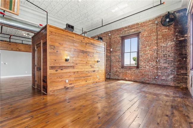 Unfurnished room with wood-type flooring, brick wall, and an ornate ceiling | Image 13