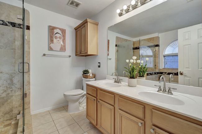 Bathroom featuring toilet, tile patterned flooring, an enclosed shower, and vanity | Image 24