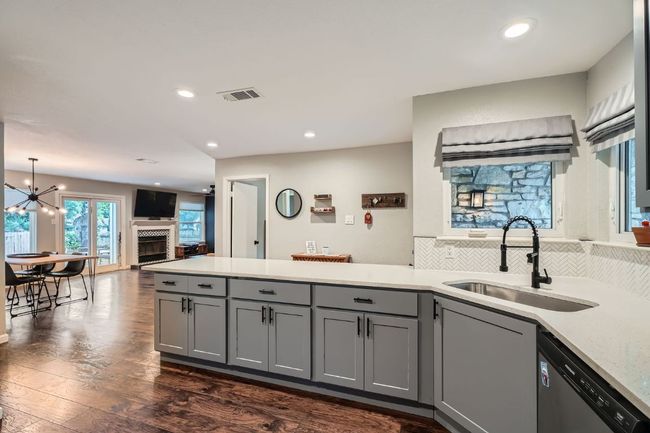 Kitchen featuring dishwasher, gray cabinets, a peninsula, dark wood-style flooring, and recessed lighting | Image 7