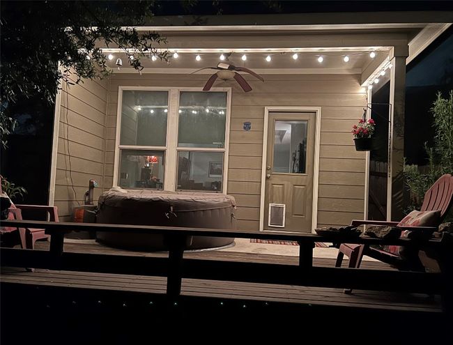 View of exterior entry with a wooden deck, ceiling fan, and a covered hot tub | Image 17