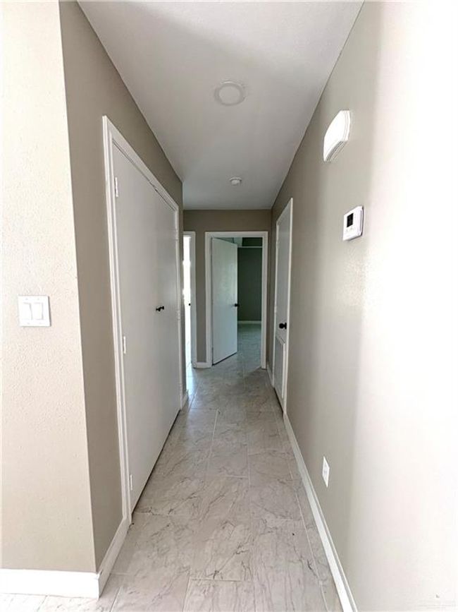 Corridor featuring light marble finish flooring and baseboards | Image 4