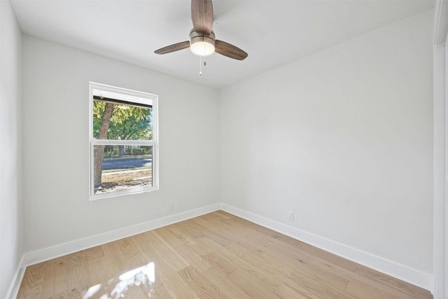 Empty room with light wood-style flooring and ceiling fan | Image 31