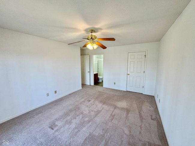 unfurnished bedroom with ceiling fan, baseboards, ensuite bath, and carpet flooring | Image 12