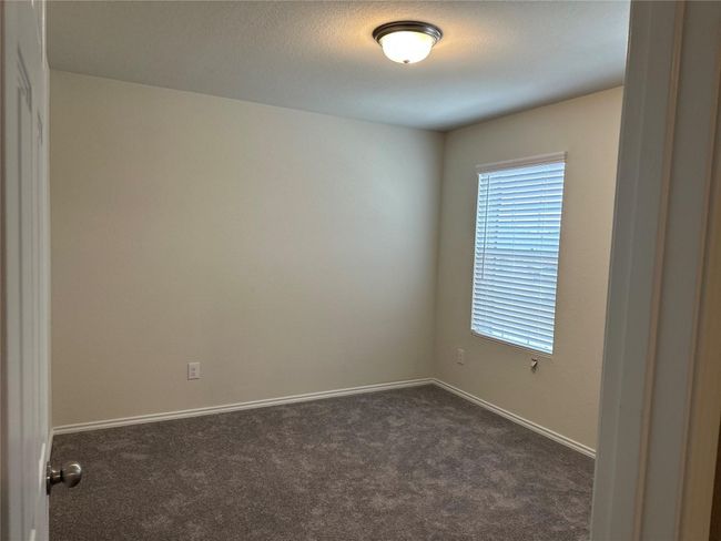 Unfurnished room with dark colored carpet and baseboards | Image 16