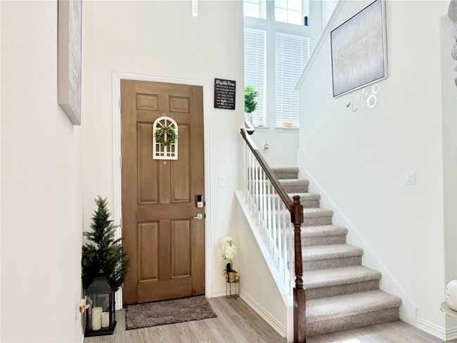 Entrance foyer featuring wood finished floors, stairs, plenty of natural light, and a high ceiling | Image 14