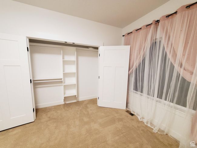 Unfurnished bedroom with a closet and light colored carpet | Image 15