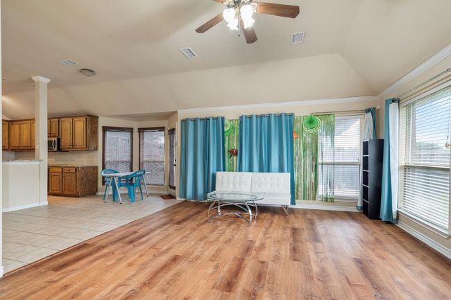 Living room with lofted ceiling, a ceiling fan, and light wood-style floors | Image 22