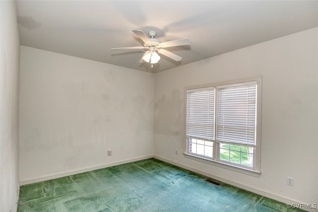 Carpeted spare room featuring visible vents, baseboards, and ceiling fan | Image 25