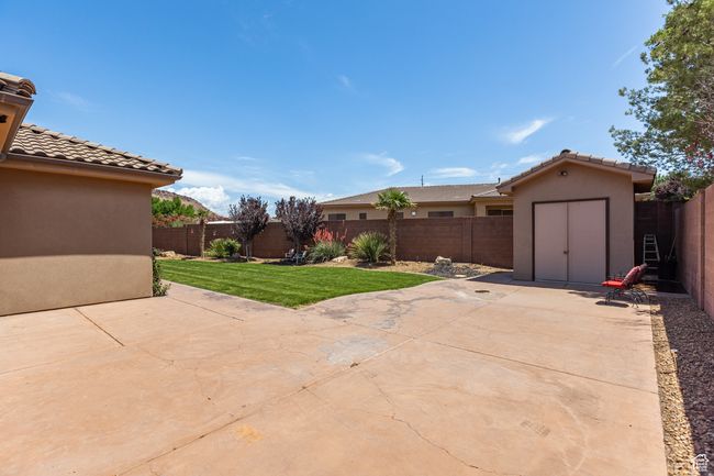 Fenced backyard with a patio area and a storage unit | Image 6