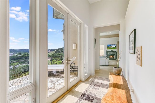 Doorway to outside with light wood-style floors and a lit fireplace | Image 4