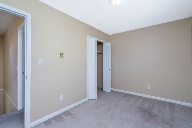 Unfurnished bedroom with baseboards, a closet, and light carpet | Image 19