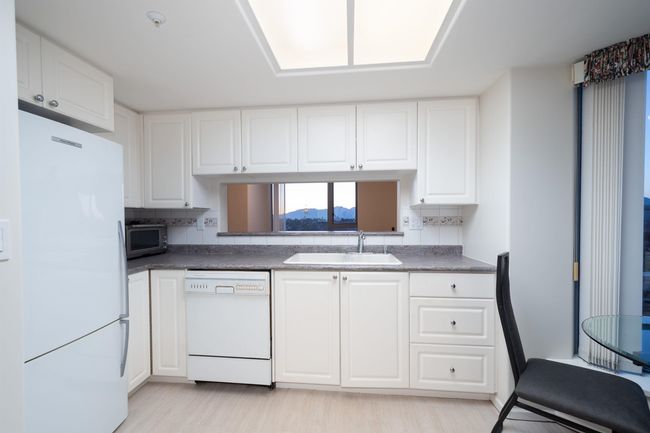 Kitchen with white cabinetry, a sink, tasteful backsplash, and white appliances | Image 18