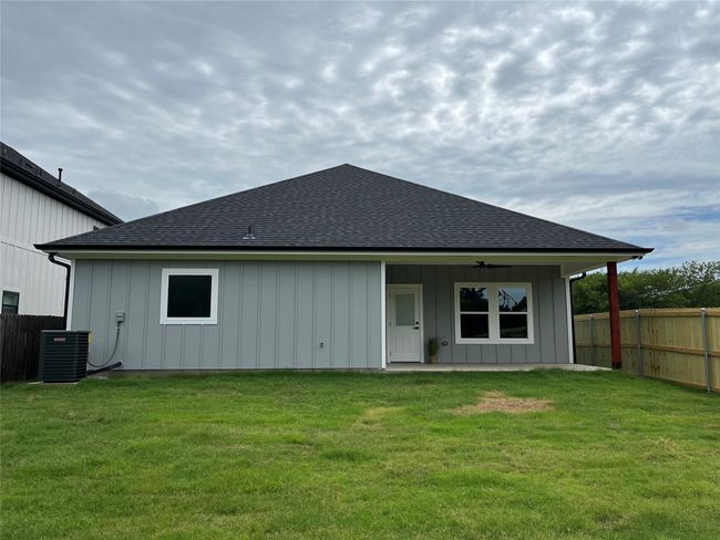 Back of property with a shingled roof, board and batten siding, a ceiling fan, and a patio | Image 31