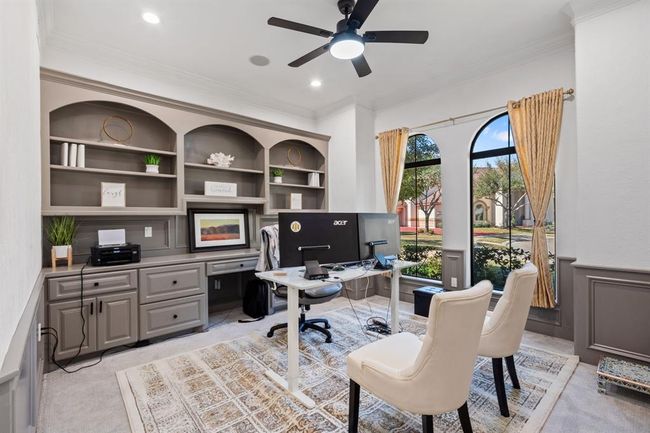 Elegant home office with double doors, arched windows, built-in shelving, and a custom desk—creating the perfect environment for productivity or quiet reflection. | Image 17